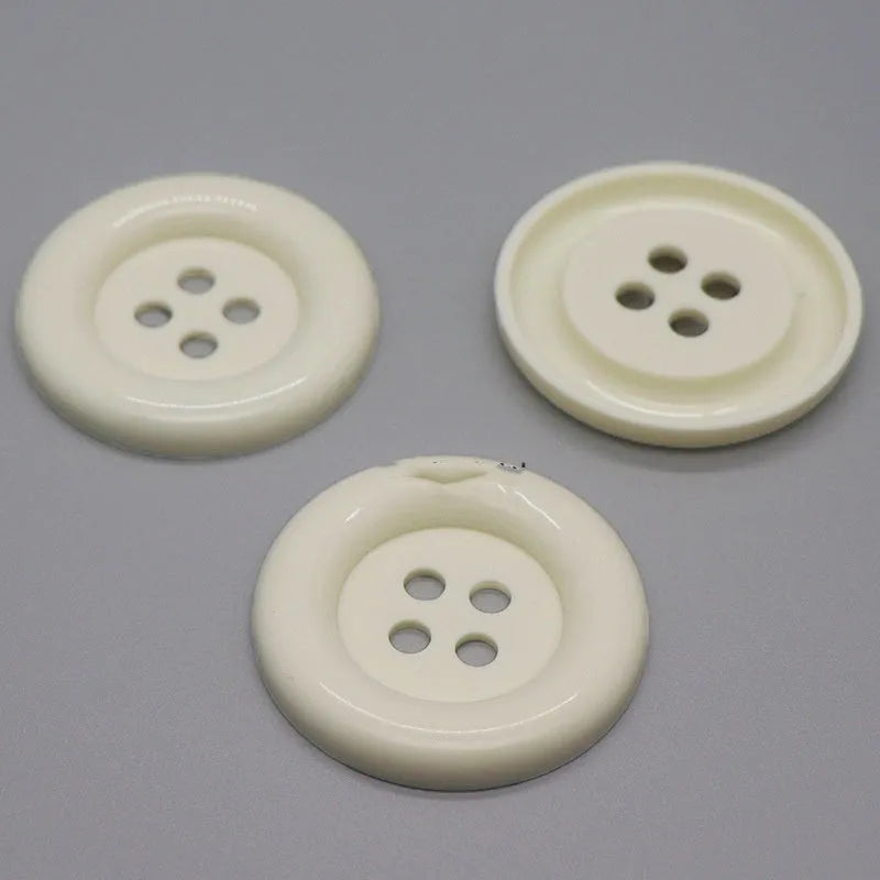 Assortment of oversized round plastic buttons in multiple colours showing four-hole design