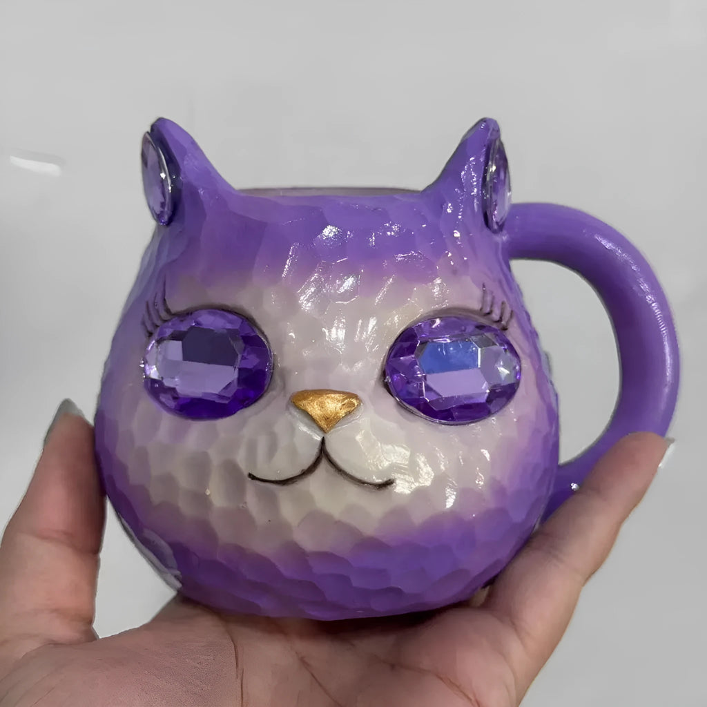 Small resin cat cup figurine in purple, green, blue, or pink colour on a shelf.