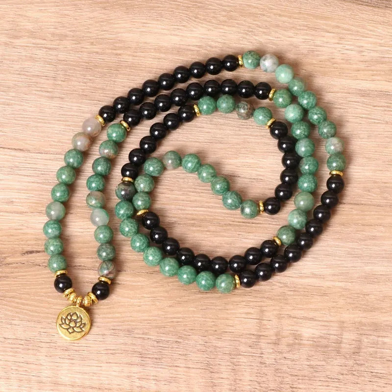 Green and black alloy bead elastic stretch bracelet on a wrist.