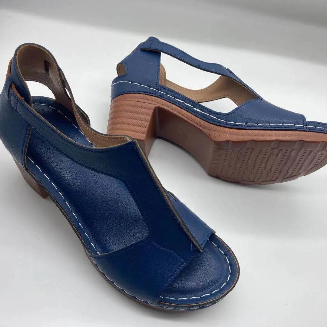 Women's beige peep toe wedge sandals with a Roman-style buckle strap on a low heel.