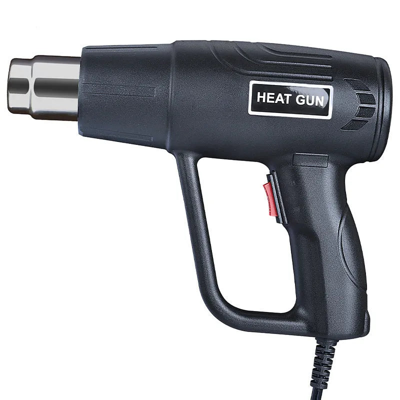 Black industrial hot air gun with a two-speed switch and grid-pattern nozzle on a workbench.