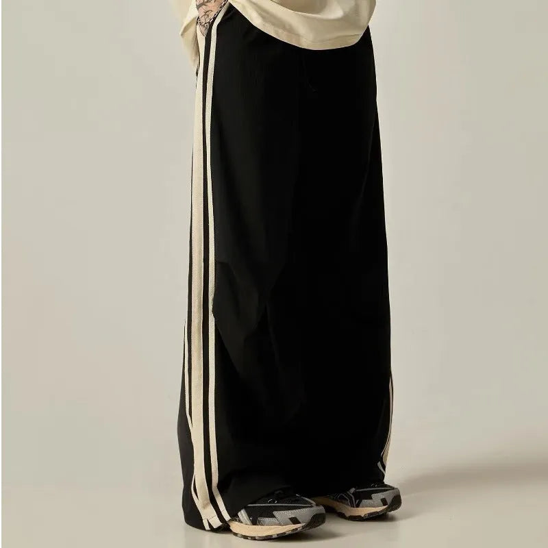 Men's black climbing trousers with high waist and wide straight leg design on hanger