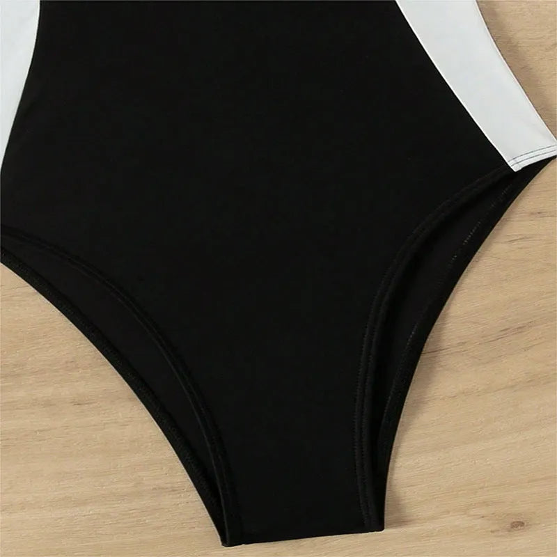 Black and white women's one-piece swimsuit with pearl spaghetti straps and a slimming cut.