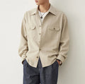 Men's light sand rice coloured lapel collar long sleeve casual shirt on a hanger.
