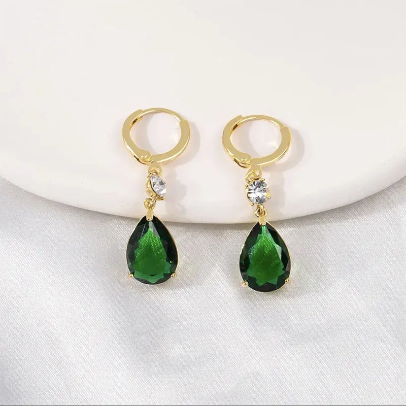 A pair of green geometric teardrop alloy earrings on a plain background.