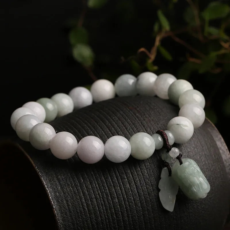 Natural green jade bracelet with a hanging Maitreya Buddha charm on a geometric band.