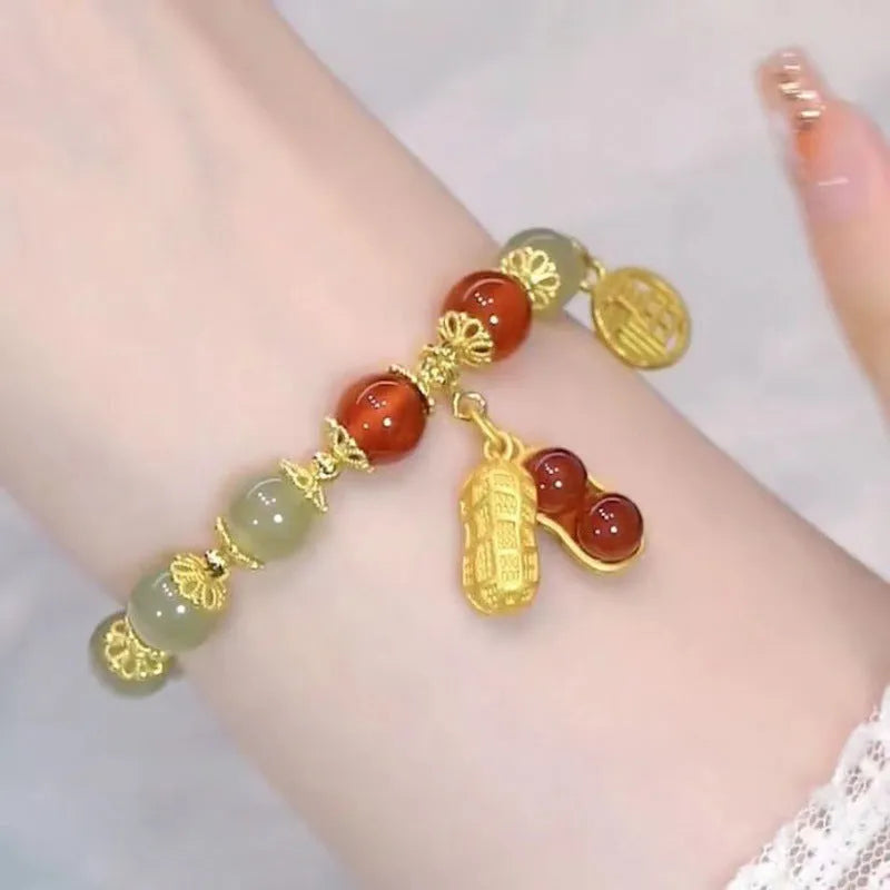 A Chinese style glass bracelet with bamboo leaf and bead designs on a wrist.