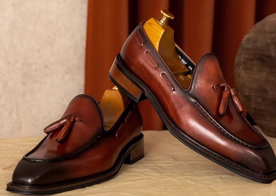 Men's black genuine leather loafers with fringed detail, rubber sole, and slip-on design