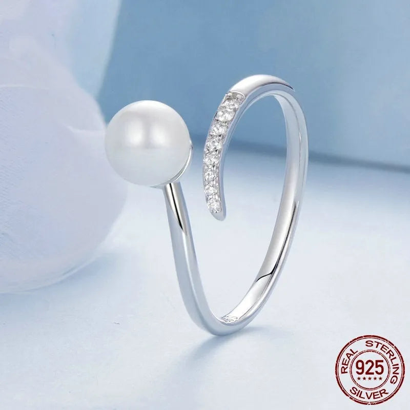 Adjustable sterling silver ring for women with a central shell pearl on an open-loop band.