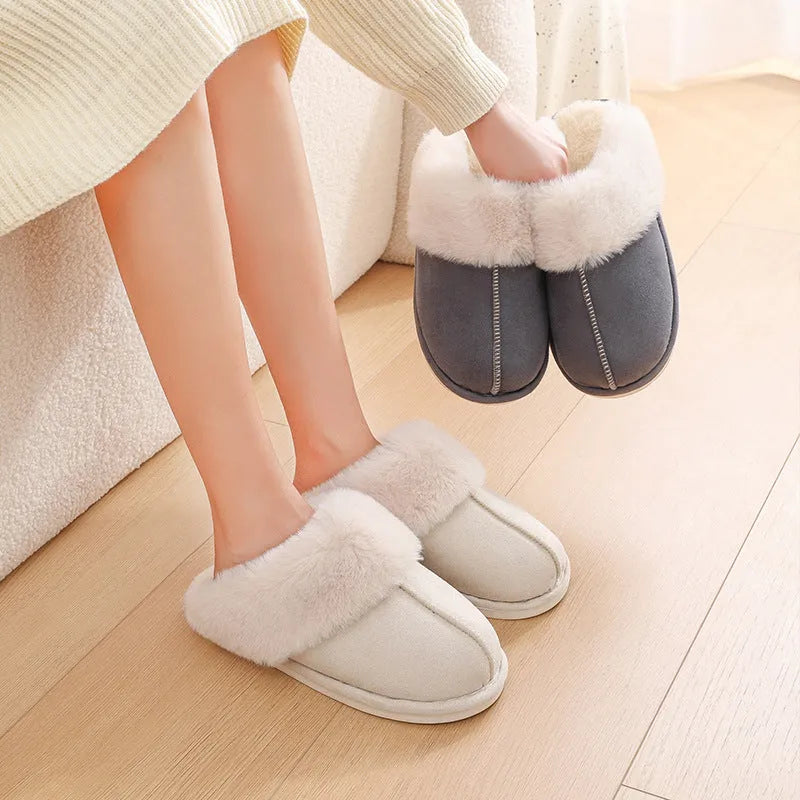 A pair of plush fur-lined indoor slippers with a round toe and a flat PVC sole.