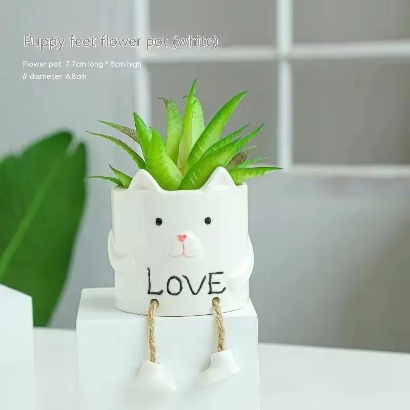 Ceramic cartoon-style succulent flowerpot with hanging foot design on desktop