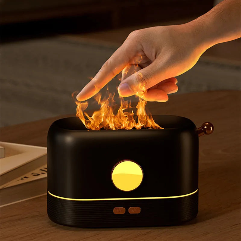 Black USB-powered humidifier with simulated orange flame effect and mist on a wooden desk.