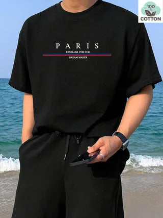 Man wearing a loose-fit, short-sleeved, grey T-shirt with a white letter print design on the chest.