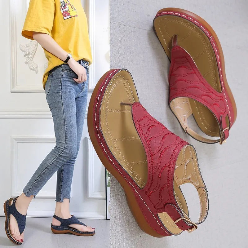 Women's wedge heel flip flop sandals in black with an adjustable back strap and buckle.