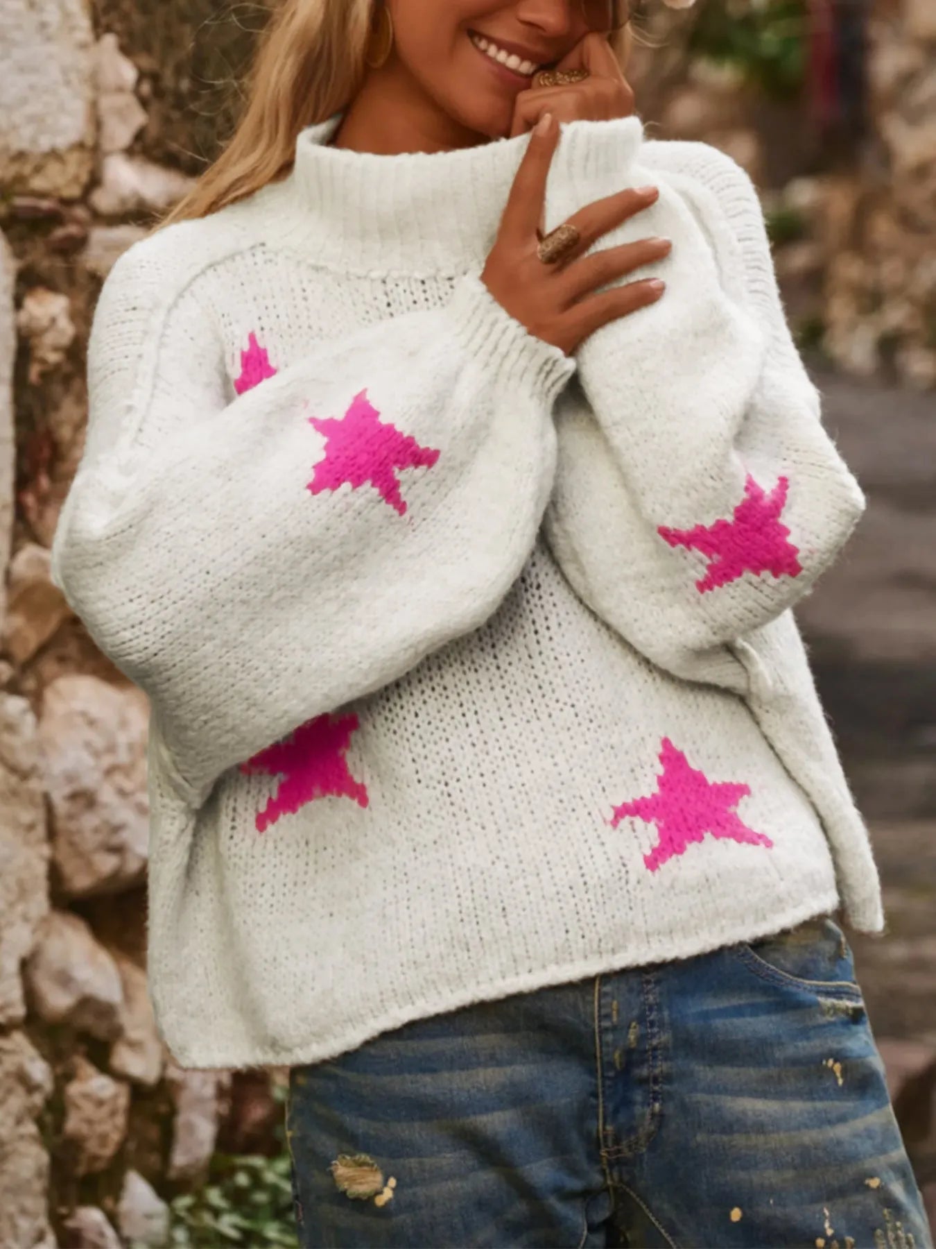 White women's loose turtleneck pullover sweater with a black five-pointed star pattern on the front.