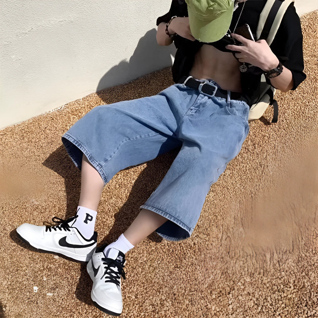 Blue men's washed denim pirate shorts with a high waist and cropped length on a hanger.