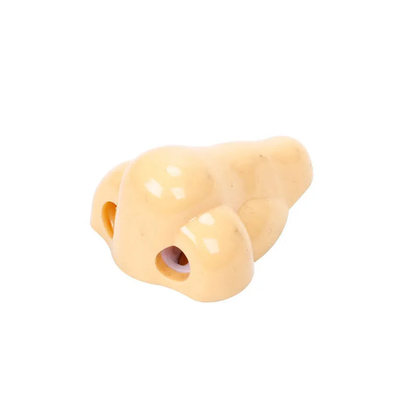 Flesh coloured plastic geometry design pencil sharpener with large casing, shown alongside a pencil.