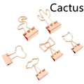Gold-coloured decorative office paper clips with long tail designs including flamingo, love, cloud, cat, cactus, and bow shapes