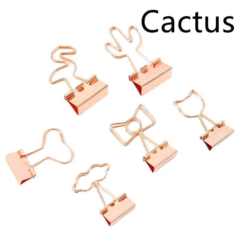 Gold-coloured decorative office paper clips with long tail designs including flamingo, love, cloud, cat, cactus, and bow shapes