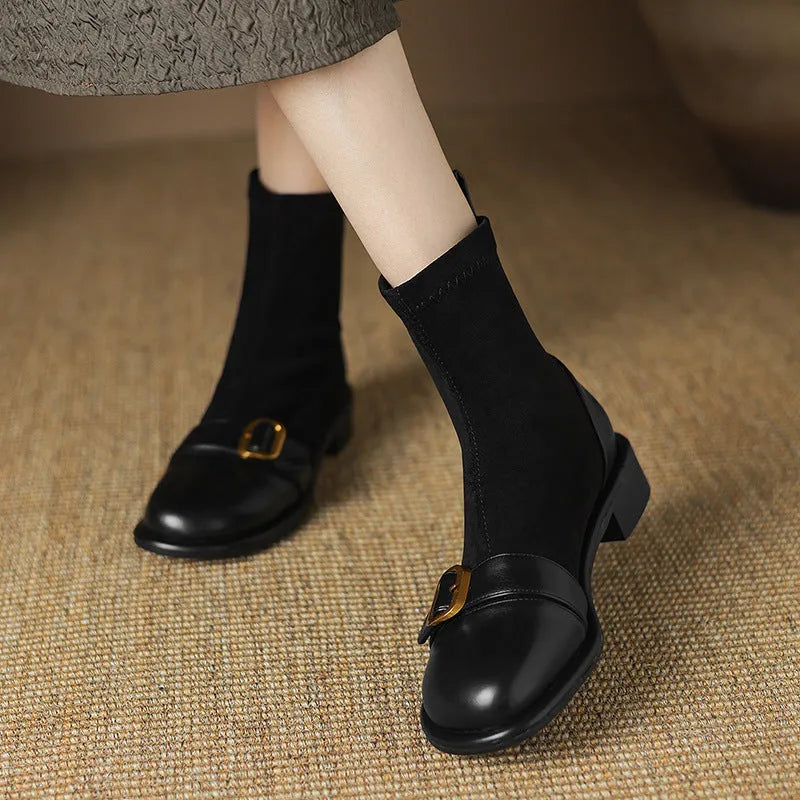 Women's black low heel Martin boots with front lace-up and belt buckle stitch detailing on a white background.