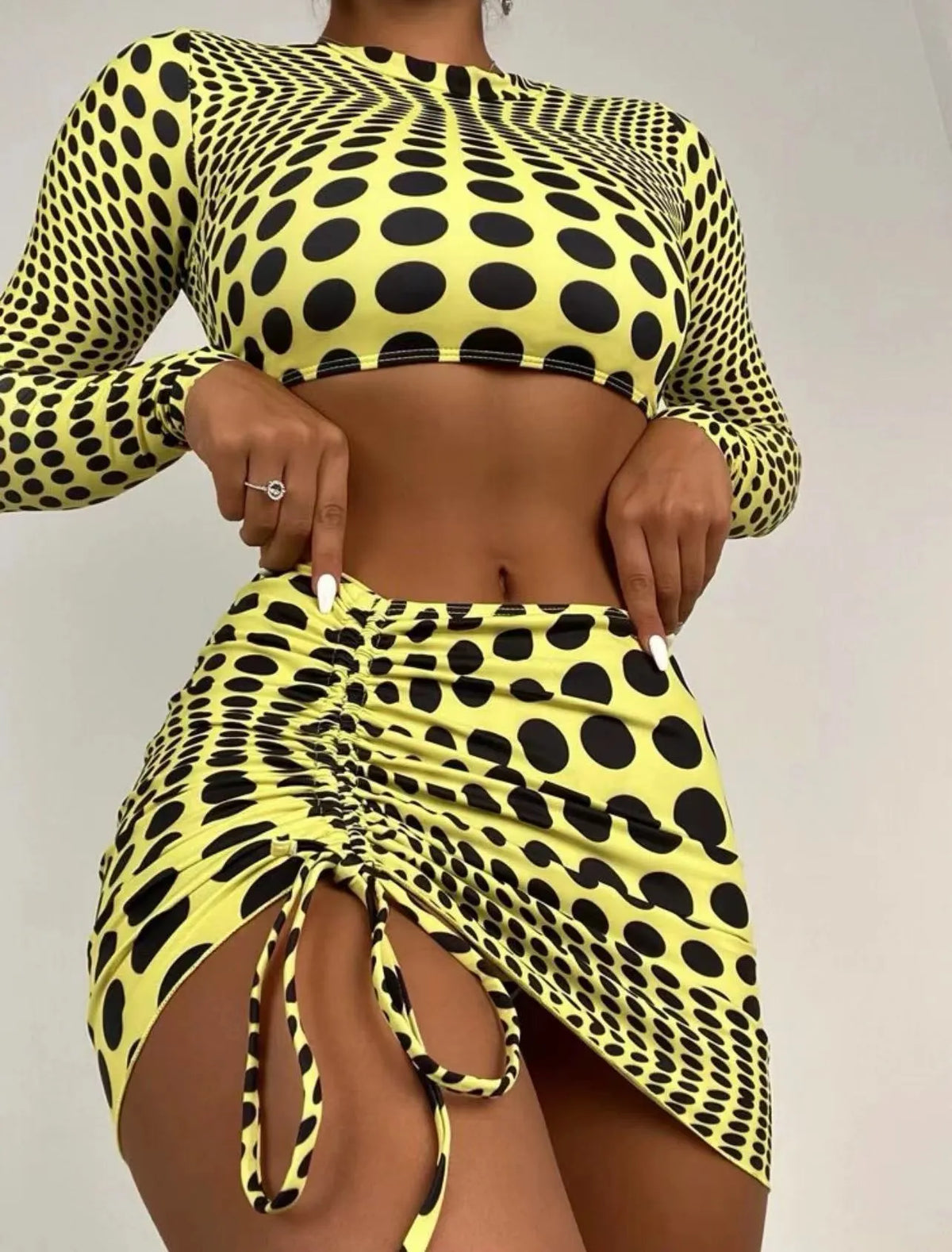 Women's green and yellow polka dot polyester swimsuit three-piece set showing top, skirt, and bra.