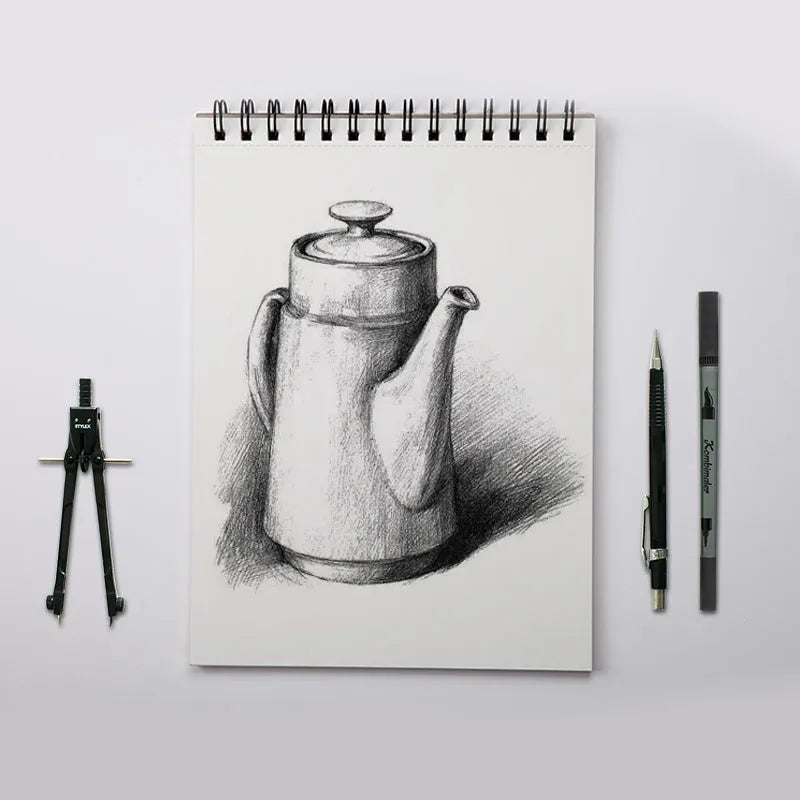 A4 sketch book with spiral coil binding lying open on a table, showing blank heavyweight paper.