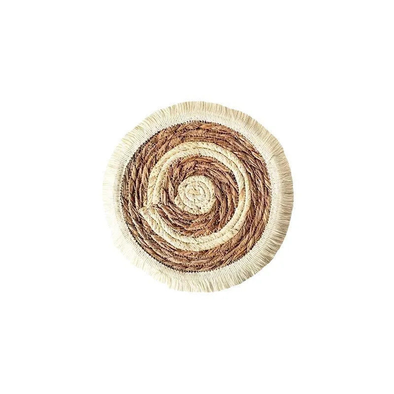 Round papyrus straw placemat with tassel edge in neutral colour on dining table