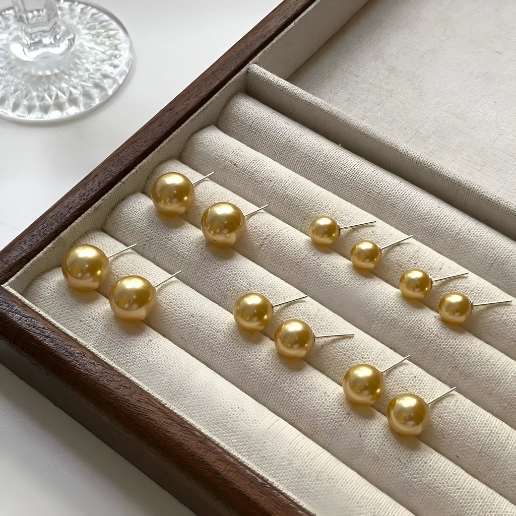 Large retro-style pearl stud earrings for women with a geometric eight-pointed star setting.