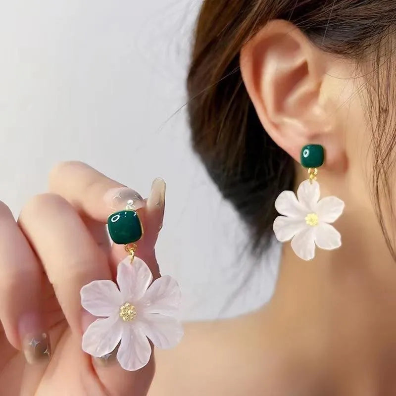 A pair of dark green and alloy needle flowers design drop earrings for women.