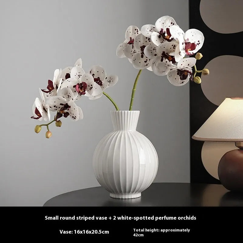White ceramic ball-shaped vase with striped American country design on a table.