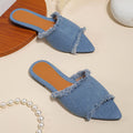 Women's denim flat slippers with a tassel detail and leather lining, shown in apricot colour.