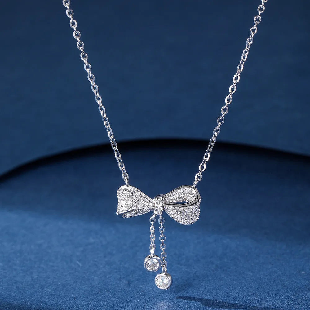 Silver bow necklace on adjustable chain showing pendant detail and polished finish