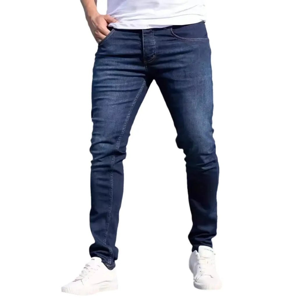 Dark blue men's slim-fit casual jeans with a worn finish and skinny leg opening.