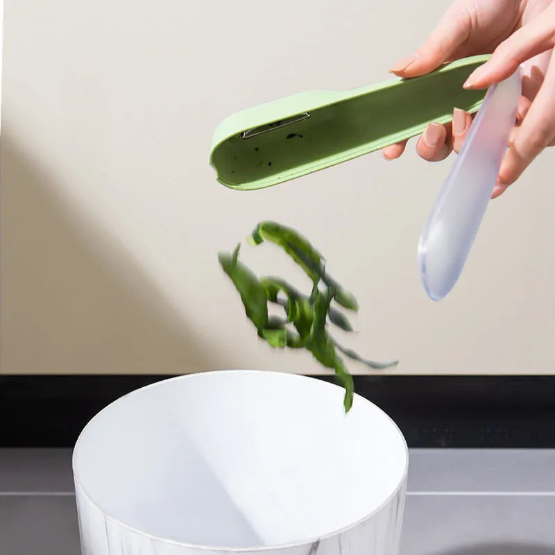 Dark green potato peeler with storage tube, stainless steel blade and plastic handle for kitchen use
