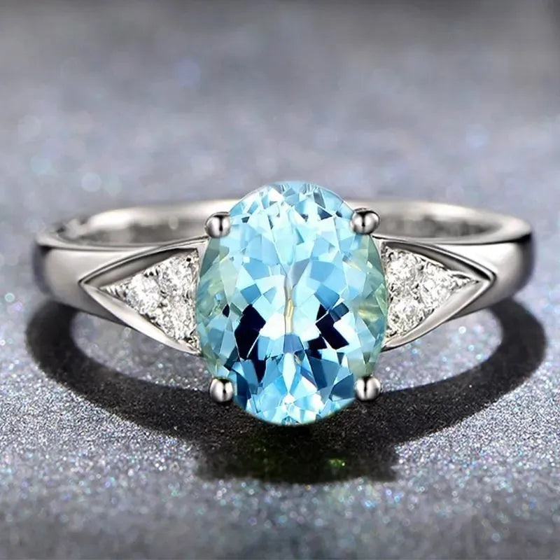 Women's court ring with natural blue zircon stones set in a delicate heart pattern on a silver-toned band.