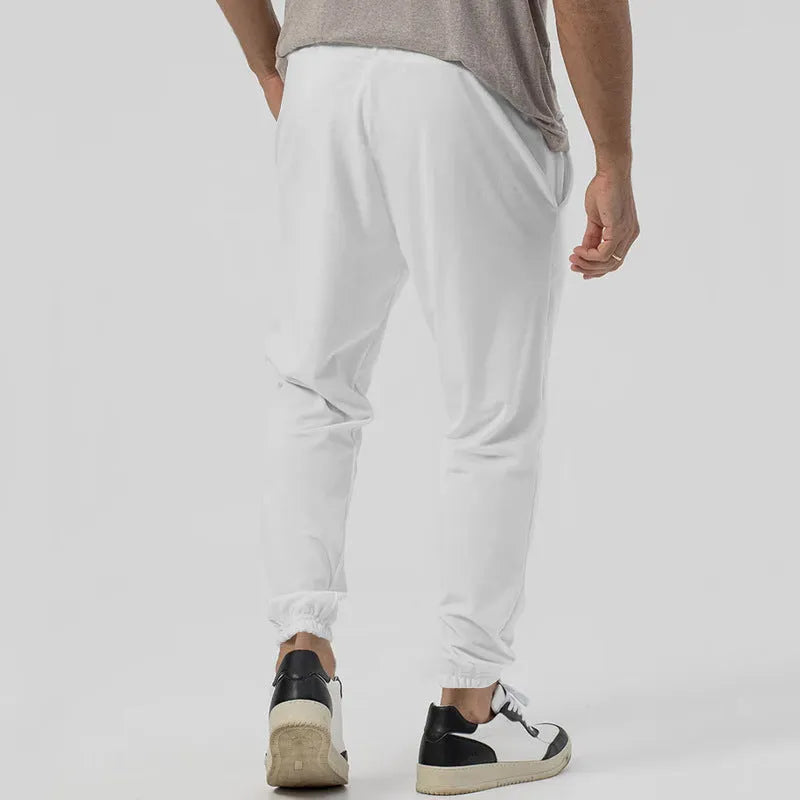 Men's grey cotton blend straight-leg track sweatpants with a mid waist and loose tapered fit on a hanger.