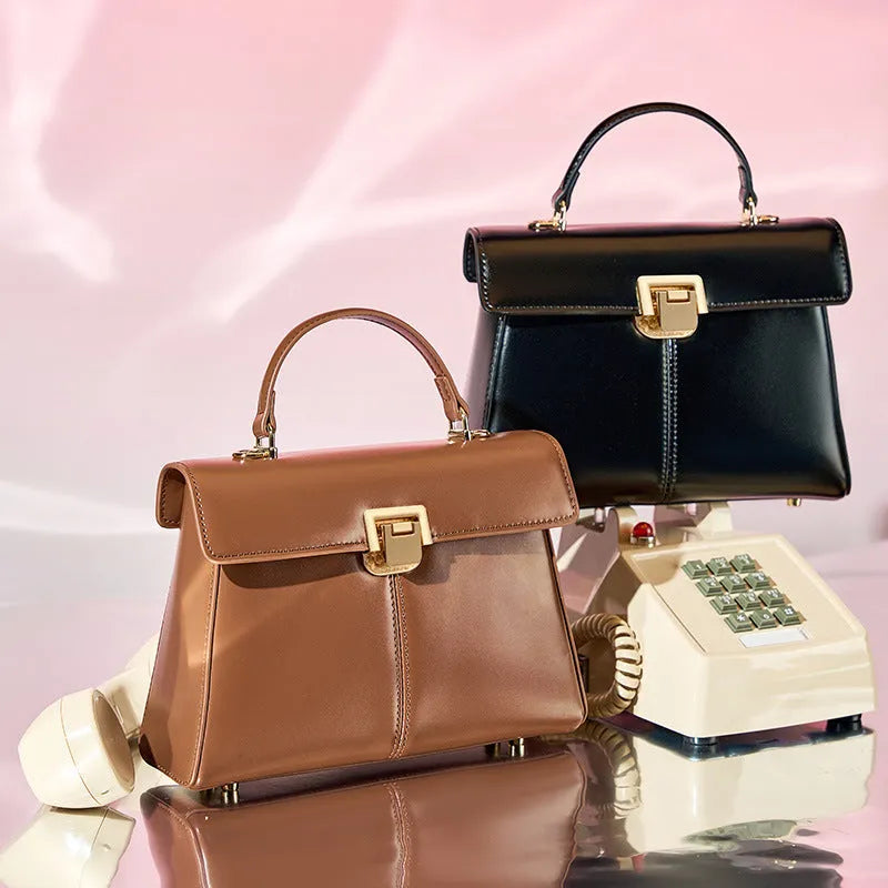 Black genuine leather shoulder bag with clasp closure showing internal compartments and adjustable strap
