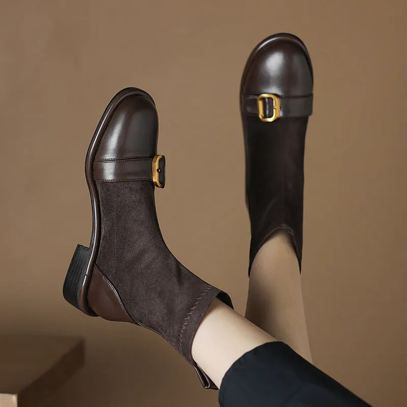 Women's black low heel Martin boots with front lace-up and belt buckle stitch detailing on a white background.