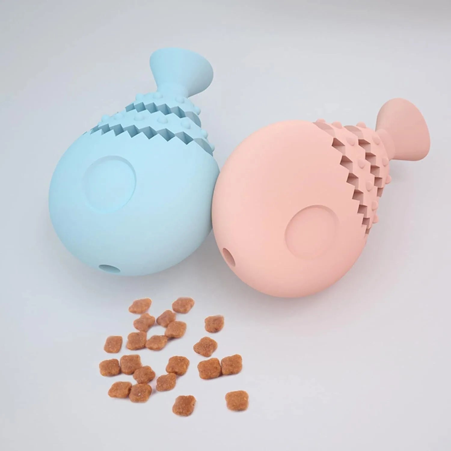 Blue, green, and pink rubber fish bone shaped dog chew toy with hollow centre for treats.