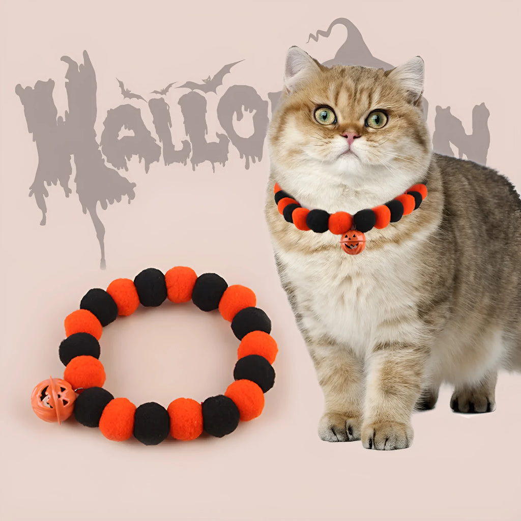 Orange Halloween cat collar with a pumpkin graphic and metal jingle bell on a black background.