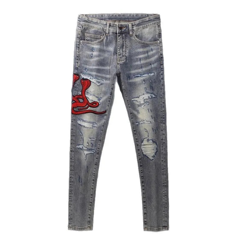 Men's vintage washed slim fit jeans with distressed holes and embroidered patch detail in old colour.