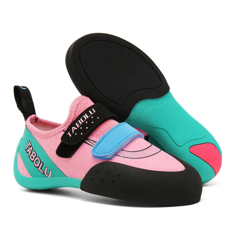 Black beginner rock climbing shoes with Velcro straps and a coloured accent on a rubber sole.
