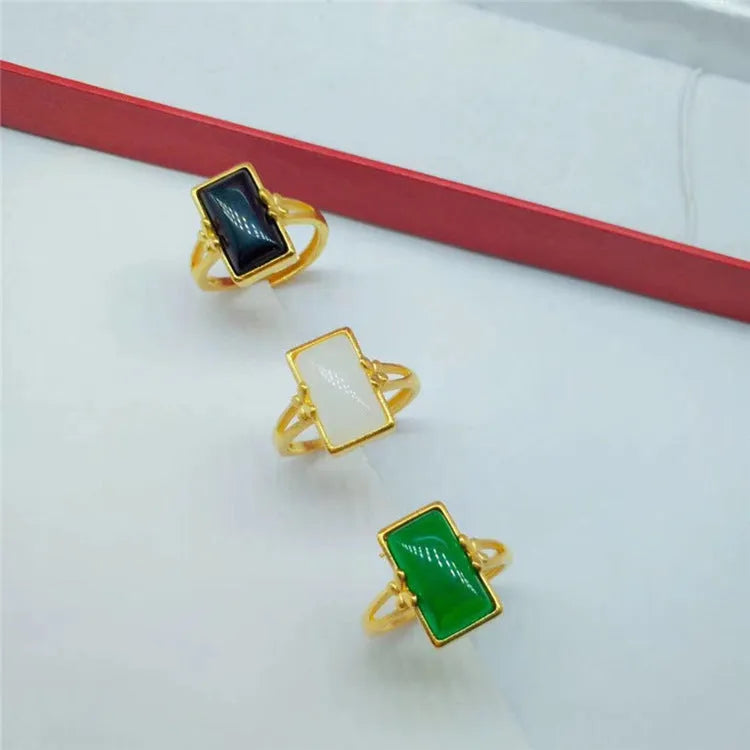 Adjustable brass gold-plated ring with an electroplated finish and a choice of black, green, or white gemstone.