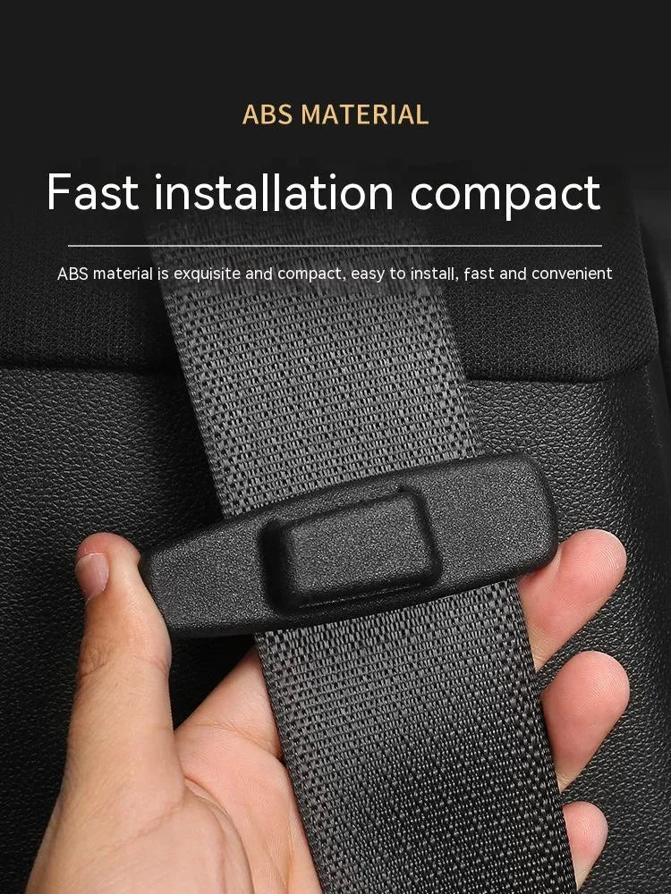 A pair of black plastic universal seat belt stopper clips on a car seat.