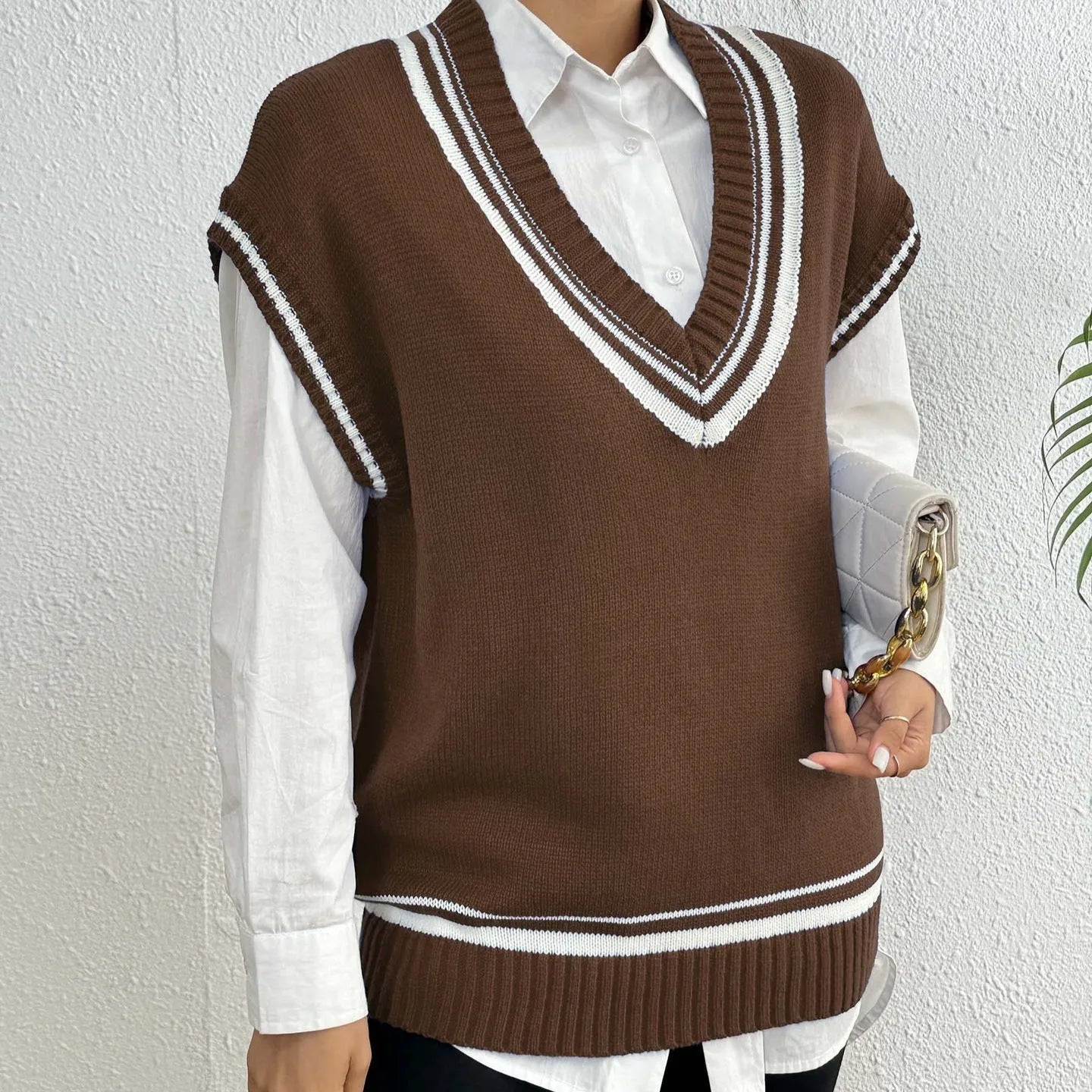 Women's loose fit college style wool vest sweater in blue, laid flat.