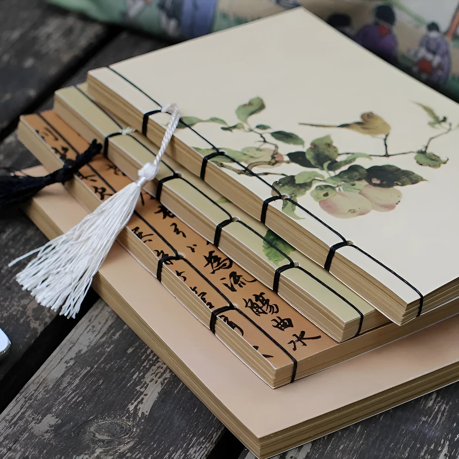 A5 antique wire-bound notebook with retro painting cover, thread binding, and black tassels.
