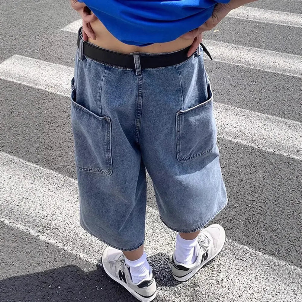 Blue men's washed denim pirate shorts with a high waist and cropped length on a hanger.