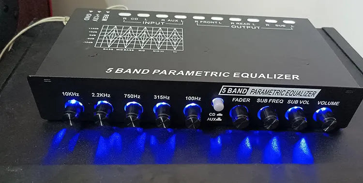 Black car audio EQ amplifier with control panel showing frequency knobs and channel indicators