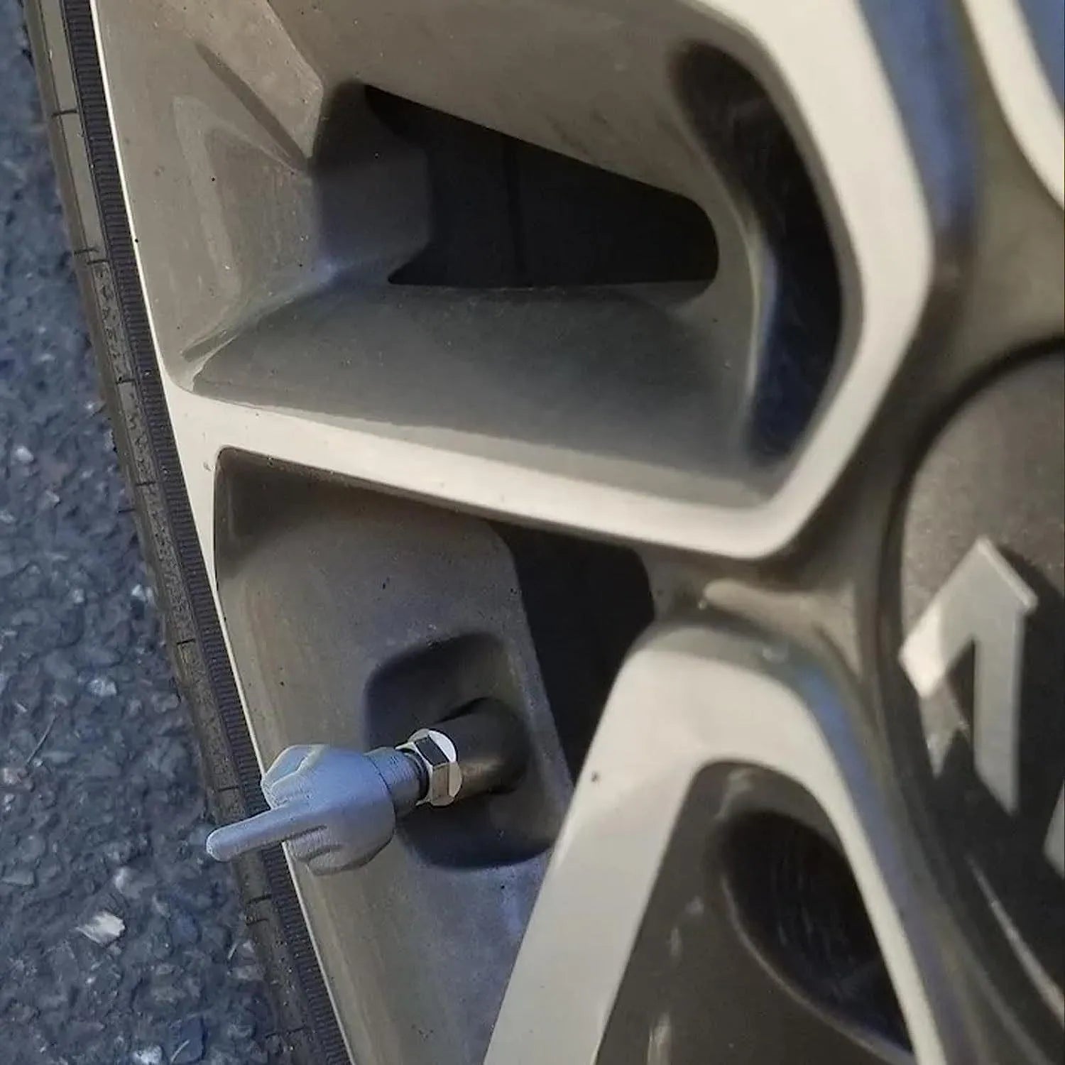 Eight car tyre valve caps, four black and four skin colour, made from latex.