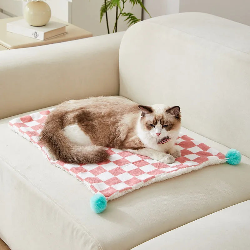 Green plaid pattern pet blanket with fur ball decoration on sofa